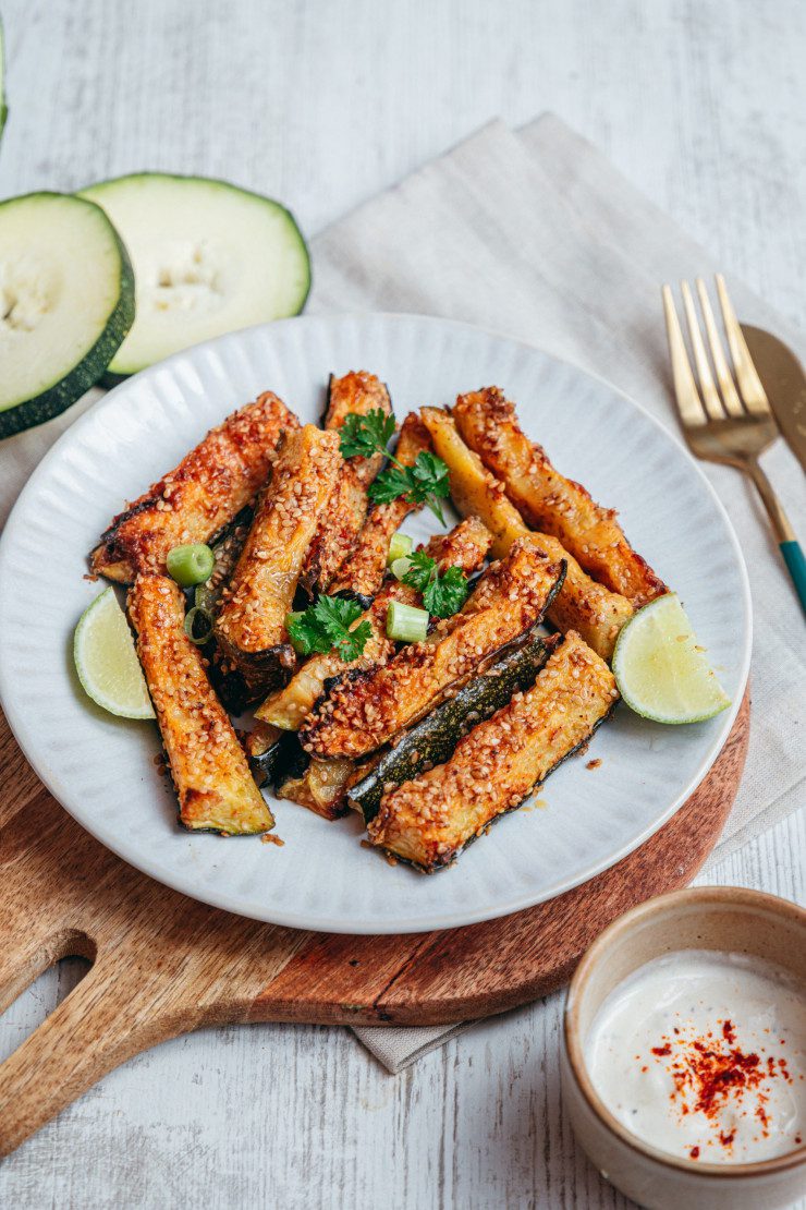 Ceci est une photographie de bâtonnets de courgettes rôtis au sésame et parmesan sans gluten et végétarien-zenglutenfree