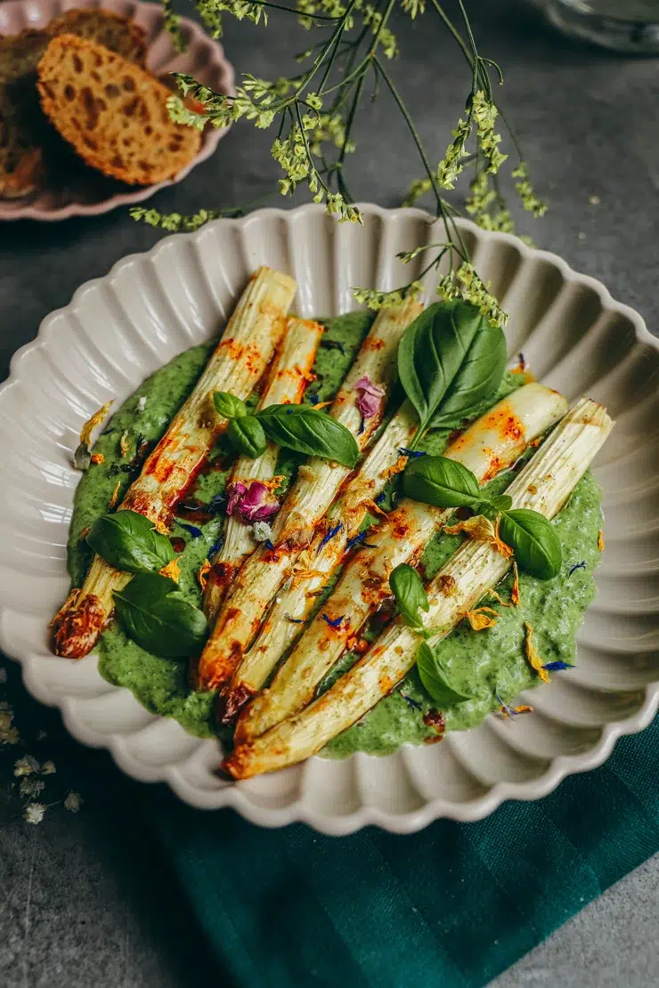 Asperges blanches rôties sans gluten dressées sur sauce verte au yaourt grec et herbes fraîches